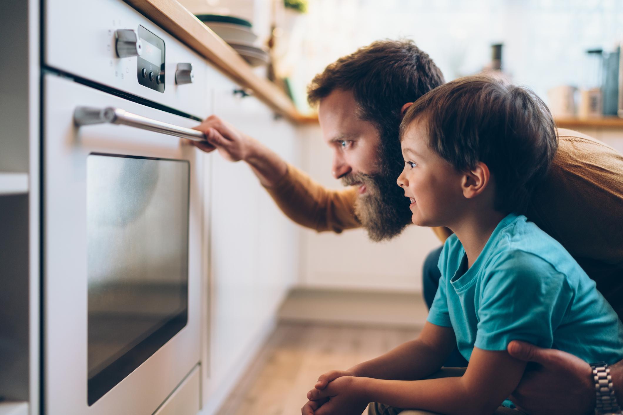 father and son at oven